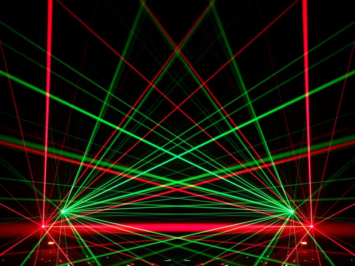 Wide fan of stage beams from a lighting rig